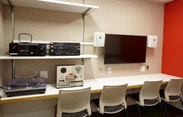 room with four chairs and various equipment for listening and viewing audio/visual materials